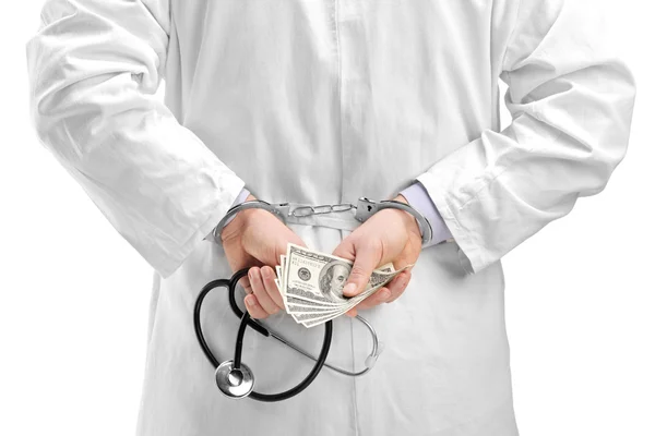 Doctor with dollar banknotes and handcuffs — Stock Photo, Image