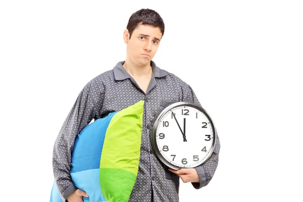 Sleepy guy holding wall clock and pillow — Stock Photo, Image