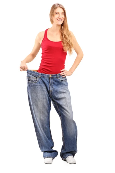 昔のジーンズで女性の損失の重量を量る — ストック写真