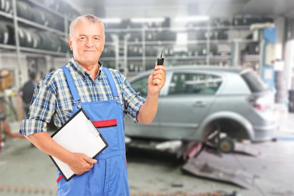 Mecánico con portapapeles y llave del coche —  Fotos de Stock