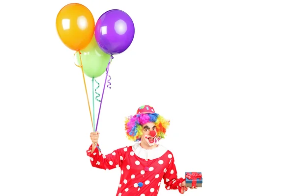 Palhaço masculino com balões e presente — Fotografia de Stock