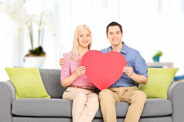 Pareja sosteniendo gran corazón rojo —  Fotos de Stock