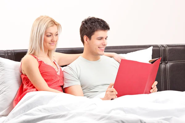 Couple on bed reading book — Stock Photo, Image