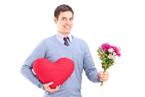 Hombre sosteniendo flores y corazón rojo — Foto de Stock