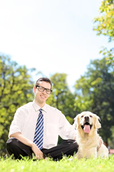 Hombre sonriente sobre hierba verde con perro — Foto de Stock