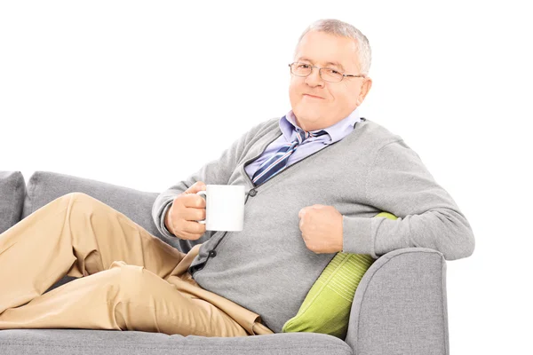 Herr trinkt Kaffee auf dem Sofa — Stockfoto