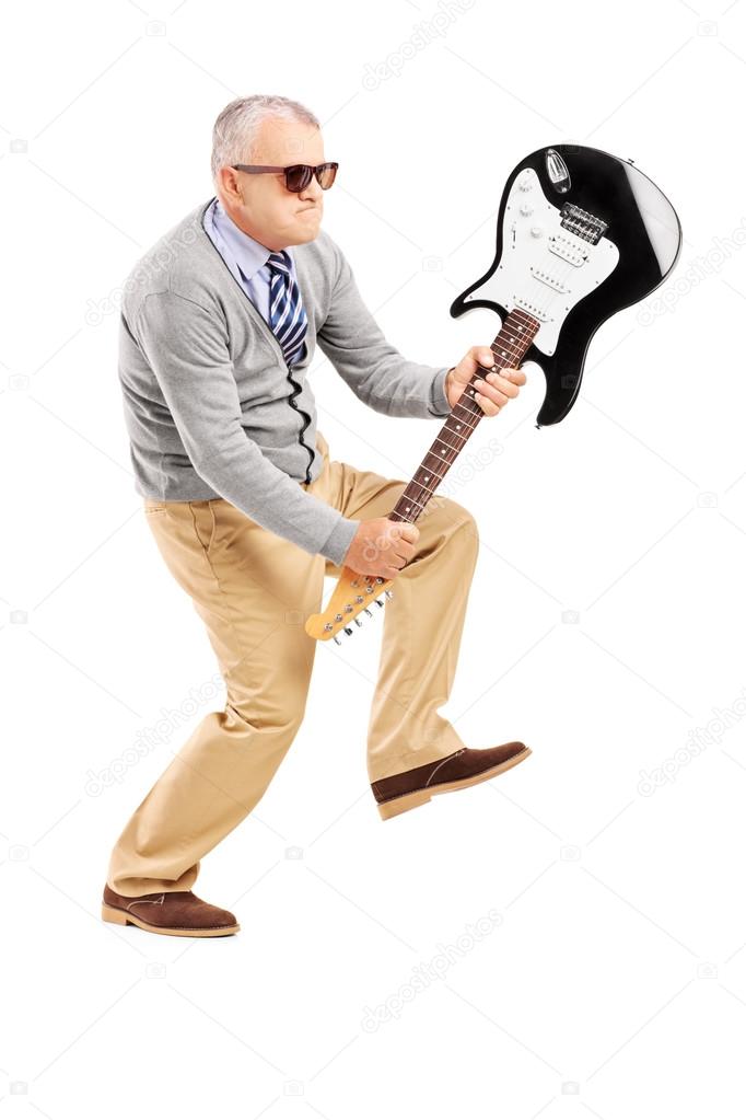 Angry mature man breaking guitar