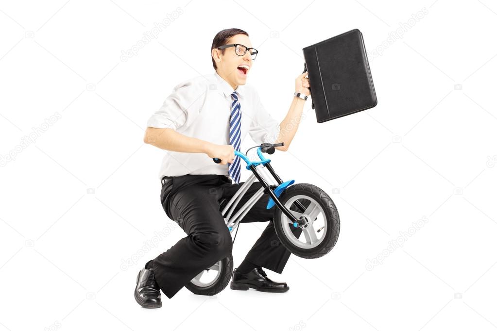 Businessman riding small bicycle