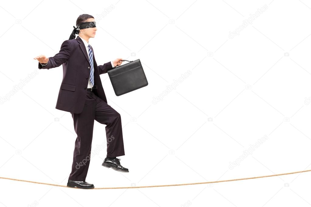 Businessman walking on rope