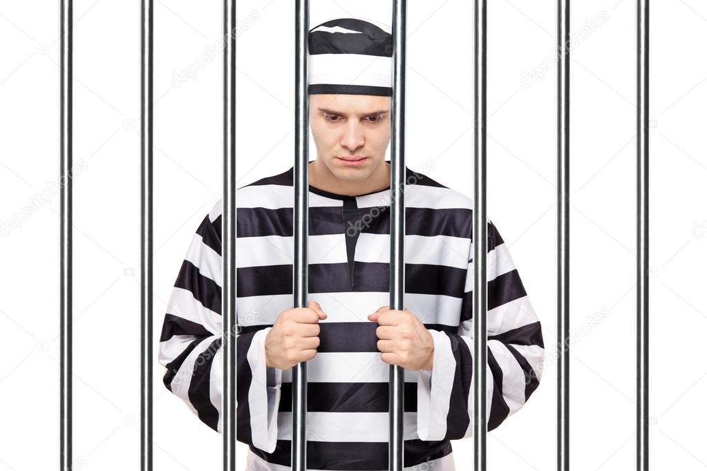 Prisoner in jail holding bars