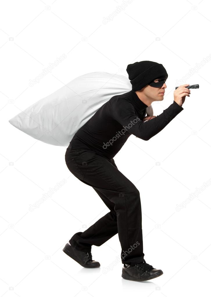 Thief carrying bag and holding torch Stock Photo by ©ljsphotography