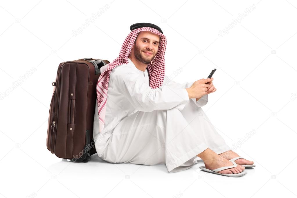 Arab man sitting near suitcase