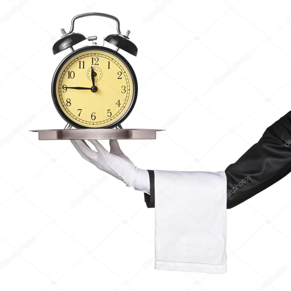 Hand holding tray with clock alarm