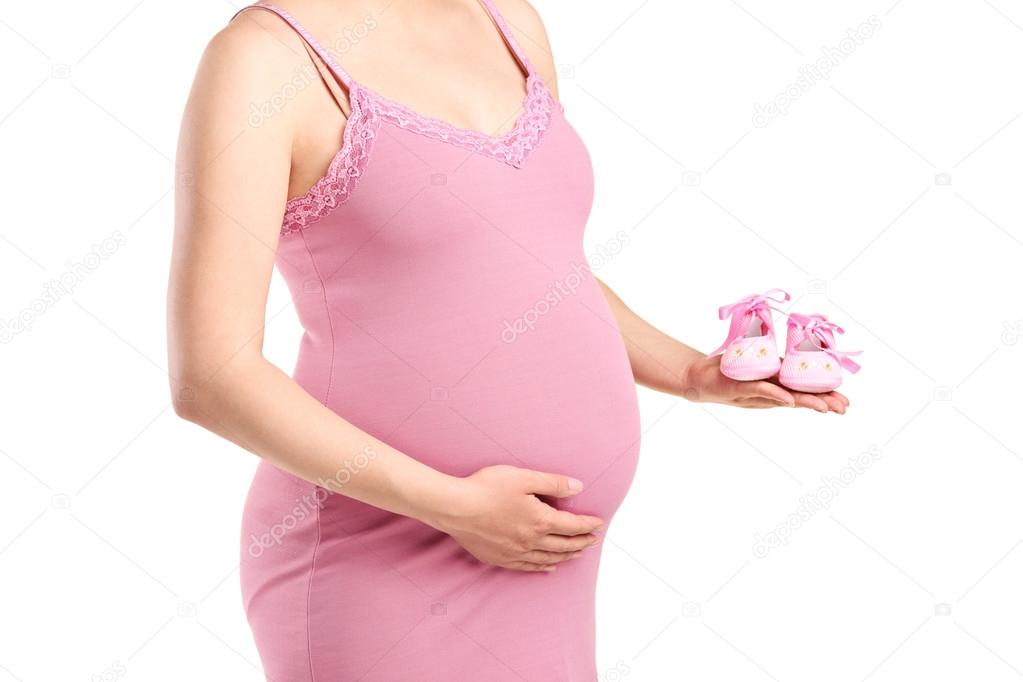 Pregnant woman holding baby shoes