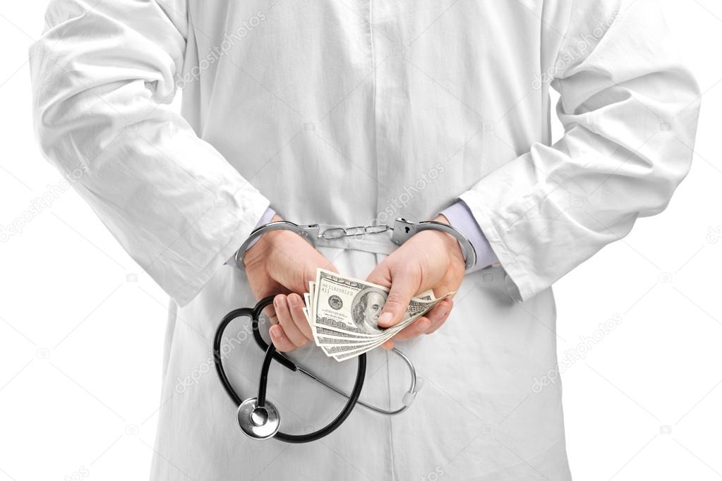 Doctor with dollar banknotes and handcuffs