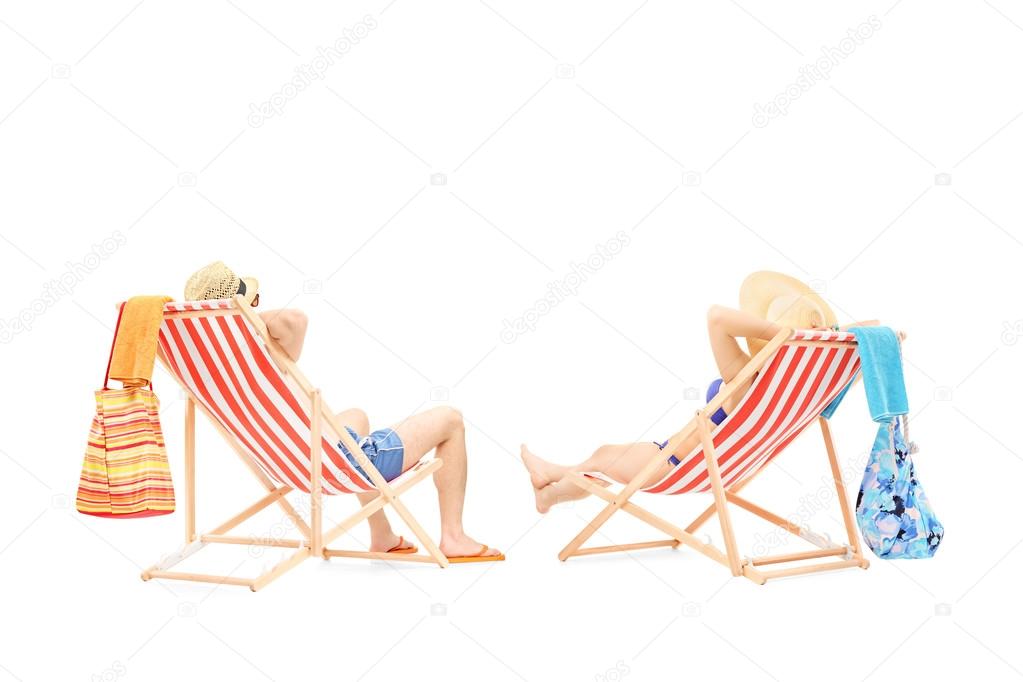 Couple relaxing on sun loungers