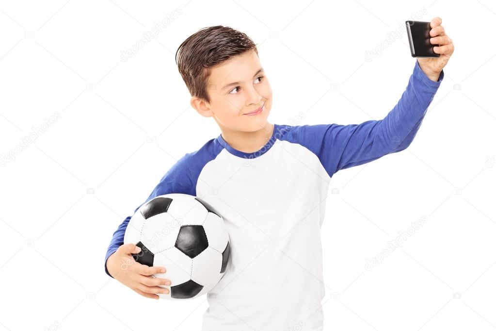 Boy holding football and taking selfie
