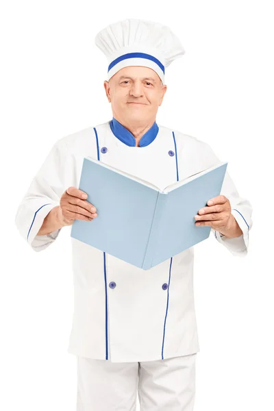 Mature chef holding cookbook — Stock Photo, Image