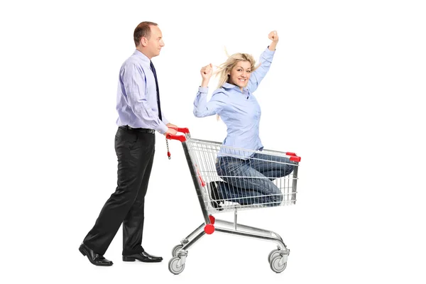 Person pushing woman in shopping cart — Stock Photo, Image