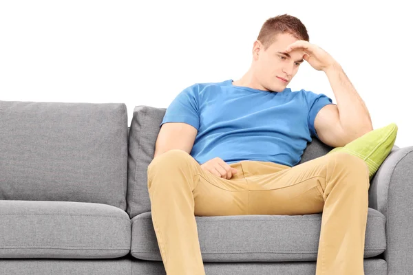 Dissappointed young man on couch — Stock Photo, Image