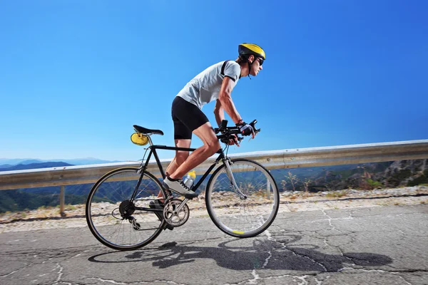 Cyclist riding bike uphill — Stock Photo, Image