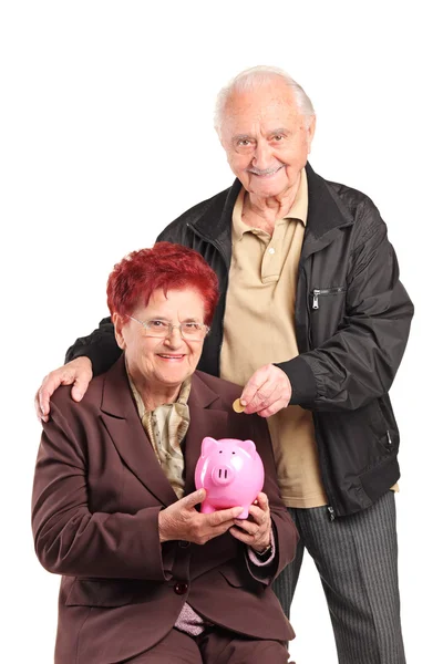 Gente madura poniendo moneda — Foto de Stock