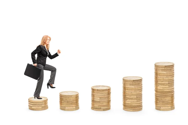 Businesswoman walking over coins — Stock Photo, Image