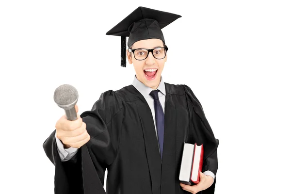 Hombre con vestido de graduación sosteniendo un micrófono —  Fotos de Stock