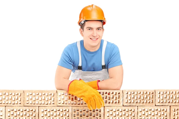 Male construction resting on brick wall — Stock Photo, Image