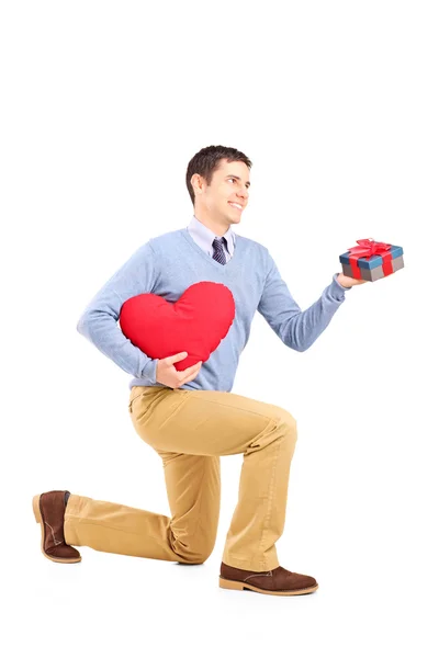 Varón arrodillado con regalo y corazón — Foto de Stock