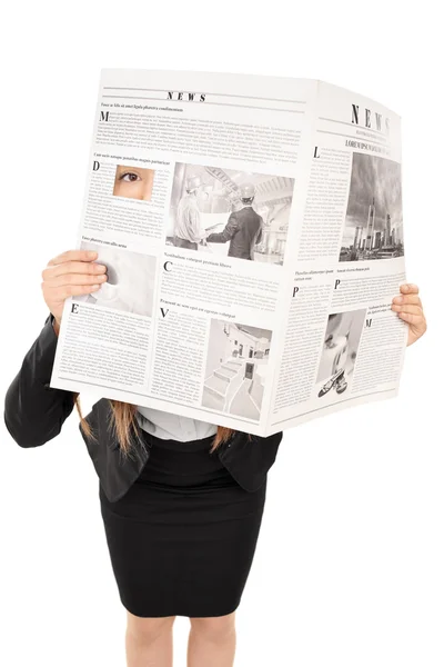 Kvinna gömmer sig bakom en tidning — Stockfoto