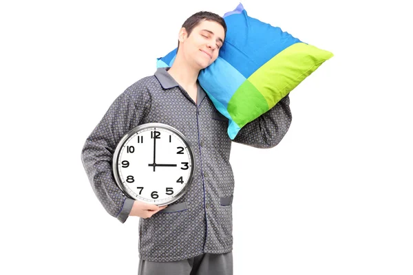 Guy holding wall clock and pillow — Stock Photo, Image