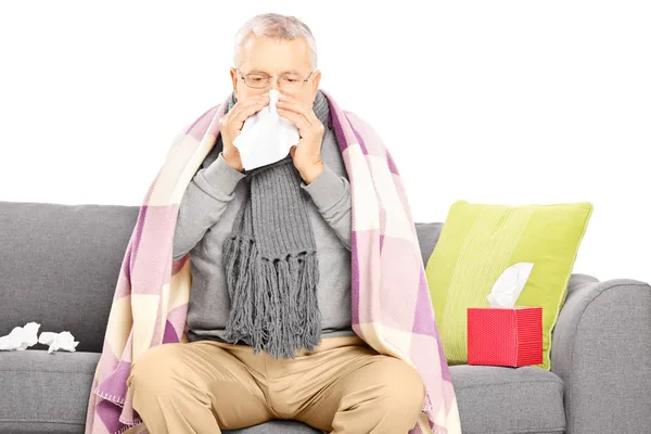 Sick senior man blowing nose — Stock Photo, Image