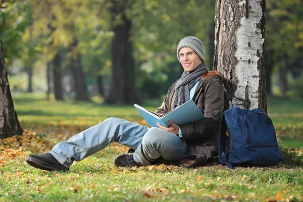 Student leesboek in park — Stockfoto