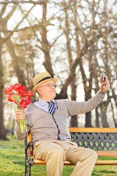 Senioren halten Tulpen in der Hand und machen Selfie — Stockfoto