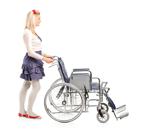 Chica joven empujando silla de ruedas — Foto de Stock