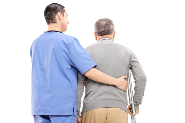 Nurse helping an elderly gentleman — Stock Photo, Image