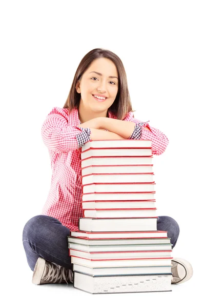 Estudante ao lado de uma pilha de livros — Fotografia de Stock