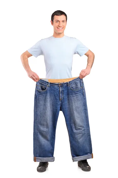 Weight loss male showing old jeans — Stock Photo, Image