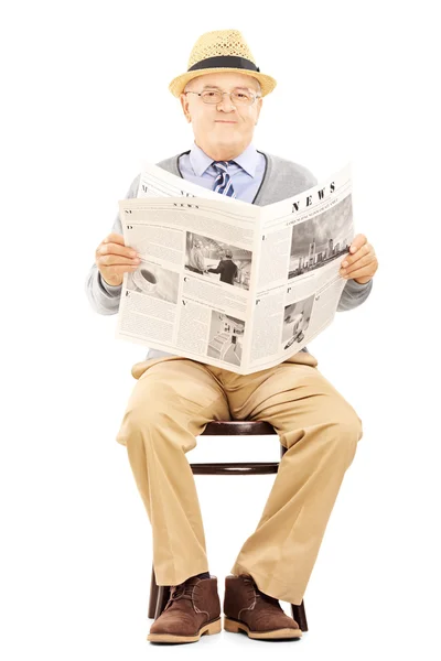 Старший джентльмен держит газету — стоковое фото