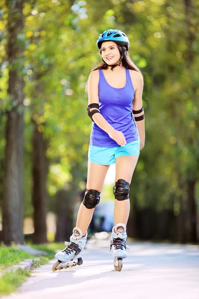 Vrouw op rollen schaatsen in park — Stockfoto