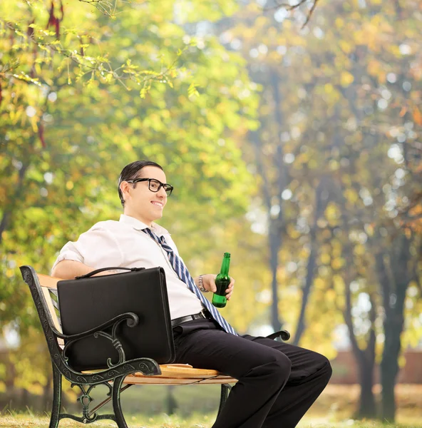 Podnikatel v parku s pivem — Stock fotografie