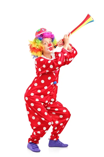Женщина-клоун, дующая в рог — стоковое фото