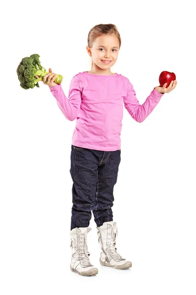 Girl holding broccoli and apple — Stock Photo, Image