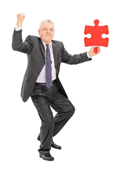 Businessman holding piece of puzzle — Stock Photo, Image