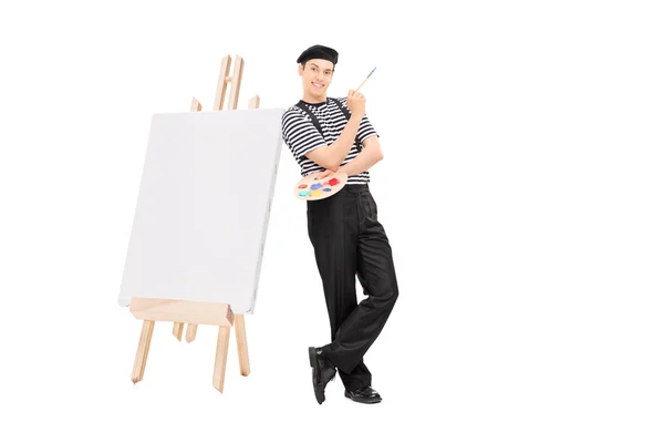 Мужчина-художник опирается на мольберт — стоковое фото