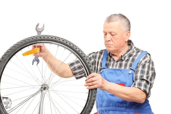 Mecânico de bicicleta olhando para a roda — Fotografia de Stock
