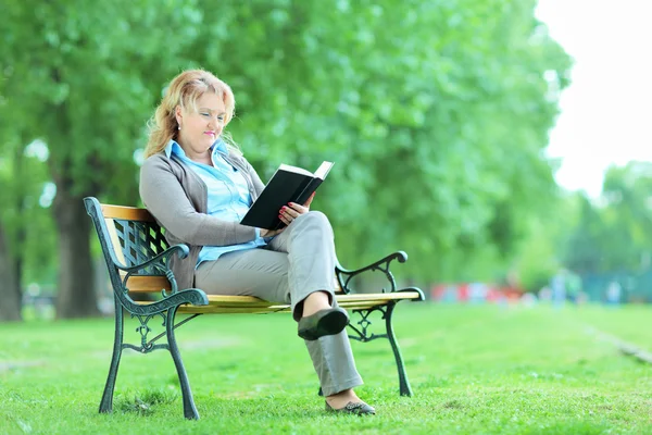 Dame mûre avec livre dans le parc — Photo