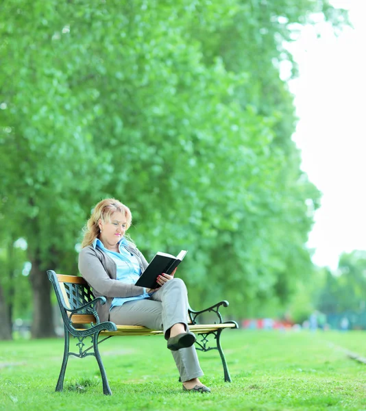 Žena čtení knihy v parku — Stock fotografie