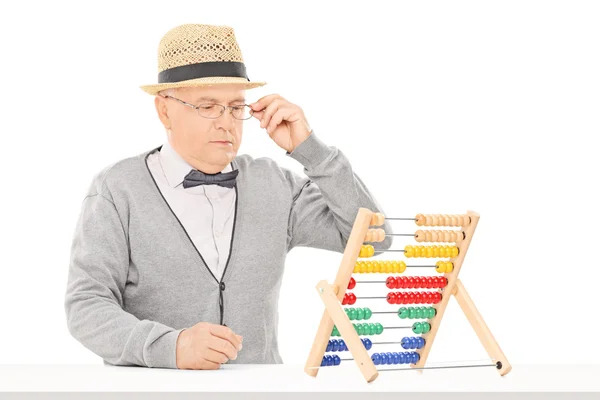 Senior man looking at abacus — Stock Photo, Image